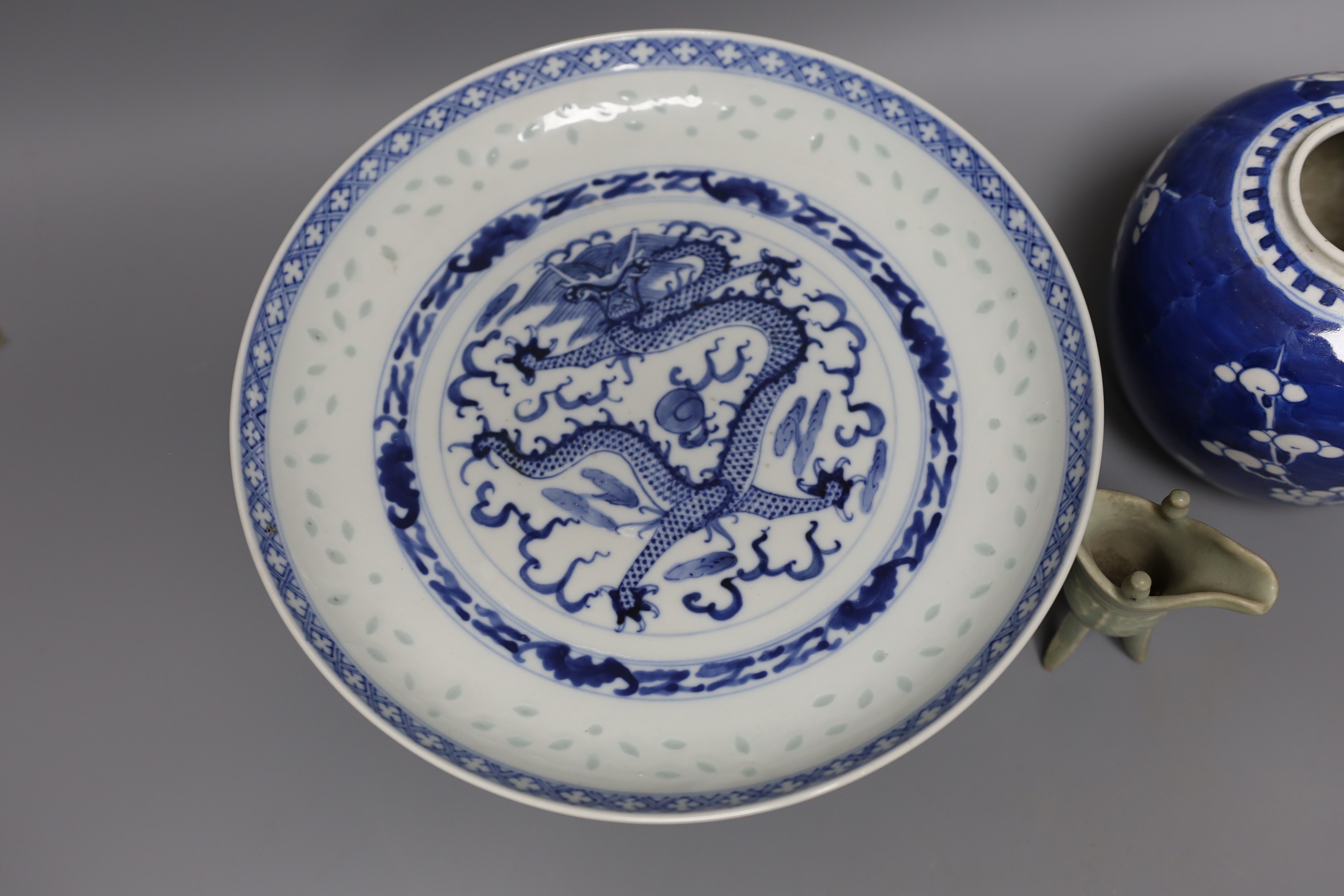 A Chinese blue and white “dragon“ footed dish, 25 cm diameter a Chinese blue and white prunus jar and a celadon glazed small vessel (3)